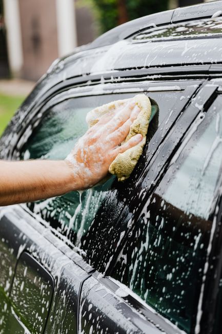 Car being hand washed with foam on location